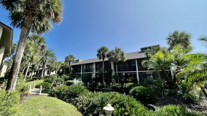 A modern building with a glass facade, surrounded by lush greenery and palm trees. - Great St. Augustine beach vacation rental at a family friendly price! (Saint Augustine)