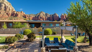 A patio with outdoor furniture, a pergola, and a view of red rock formations. - Sedona Splendor: A luxurious 3BR home in West Sedona with stunning red rock views. (Sedona)