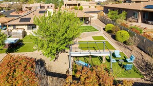 A residential area with houses, a patio with outdoor furniture, and a mountain in the background. - Sedona Splendor: A luxurious 3BR home in West Sedona with stunning red rock views. (Sedona)