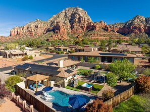 A residential area with houses, a swimming pool, and a mountain backdrop.
