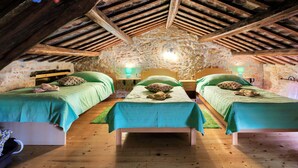 A rustic attic bedroom with three beds, wooden beams, stone walls, and a skylight. - Stunning  villa for 7 guests with WIFI, A/C, private pool, TV, terrace and pets allowed (Vodnjan)