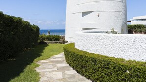 A white cylindrical building with a stone pathway leading to it, surrounded by greenery and a clear blue sky. - Beautiful private villa for 8 people with hot tub, WIFI, A/C, TV, terrace and pets allowed (Santa Marinella)