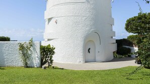 A white, circular building with a door and windows, surrounded by a well-maintained lawn and trees. - Beautiful private villa for 8 people with hot tub, WIFI, A/C, TV, terrace and pets allowed (Santa Marinella)