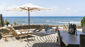 A terrace with lounge chairs, an umbrella, and a view of the ocean. - Beautiful private villa for 8 people with hot tub, WIFI, A/C, TV, terrace and pets allowed (Santa Marinella)