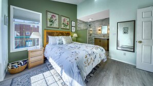 Un dormitorio con cama, mesita de noche, cómoda, ventana con persianas y puerta.
