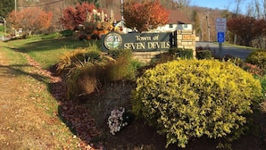 Un panneau indiquant l’entrée de la ville de Seven Devils, avec un jardin aménagé au premier plan.
