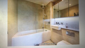Ein modernes Badezimmer mit einer gläsernen Duschkabine, einer freistehenden Badewanne und einem Waschtisch mit Spiegel.