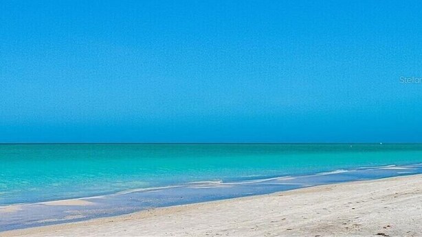 Een strand met helder turquoise water en een zandstrand.