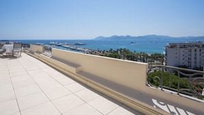 A terrace with a view of the sea, boats, and distant mountains. - Art Deco Luxury Apartment (Cannes)