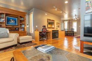 A spacious living room with a fireplace, a dining area, and a kitchen.