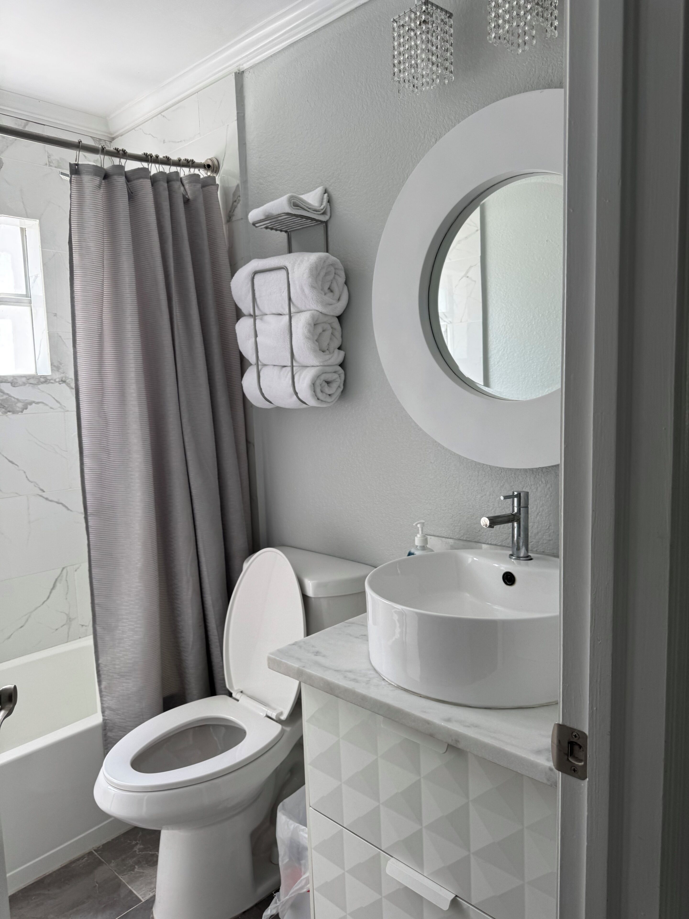 A bathroom with a toilet, sink, and shower curtain.
