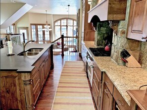 Enjoy cooking in this well-equipped kitchen with a central island, stove, and wooden cabinetry.