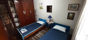 Habitación básica, 2 camas individuales | Tabla de planchar con plancha, wifi gratis y ropa de cama 
