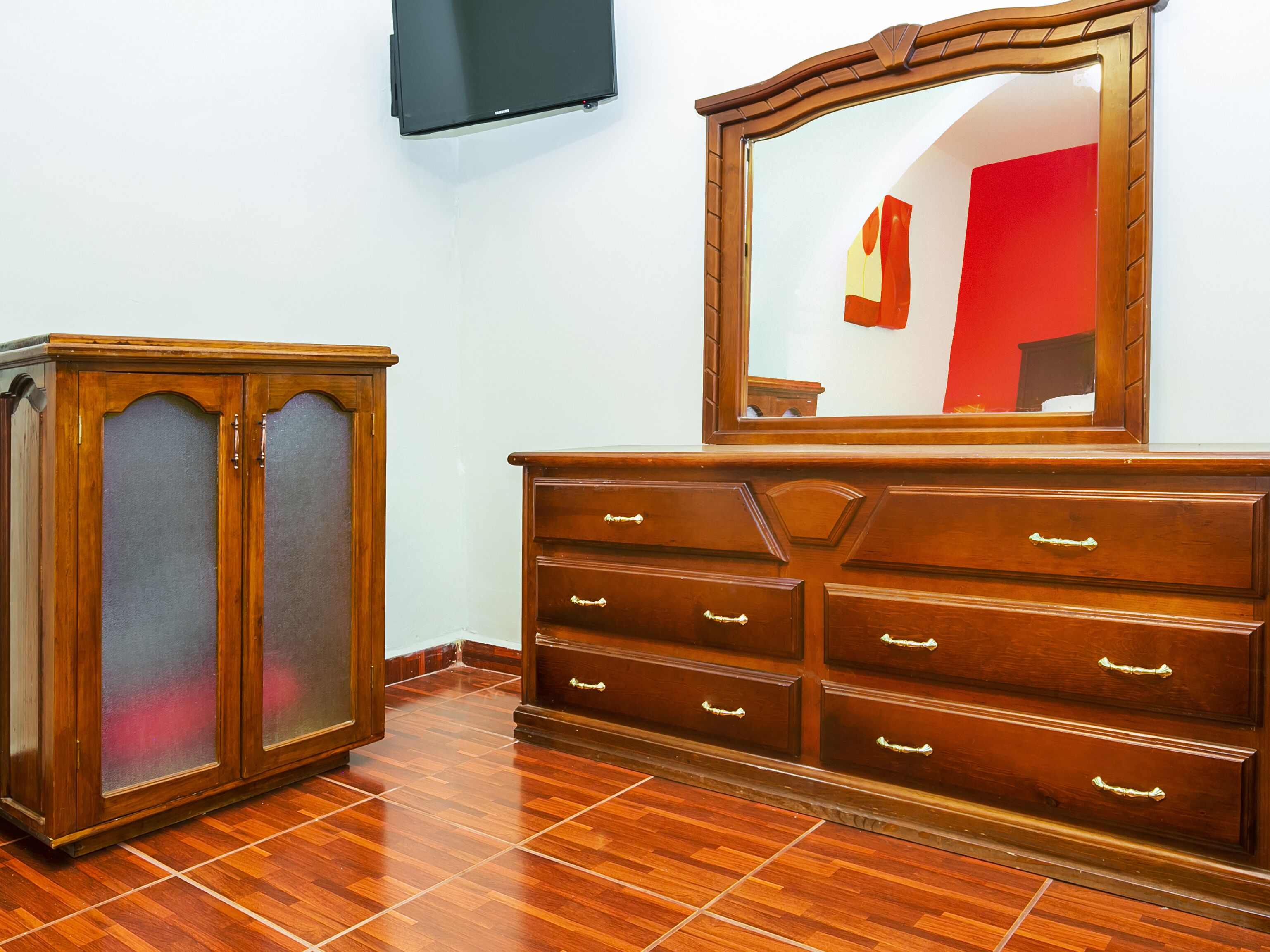 A wooden dresser with multiple drawers and a mirror above it.