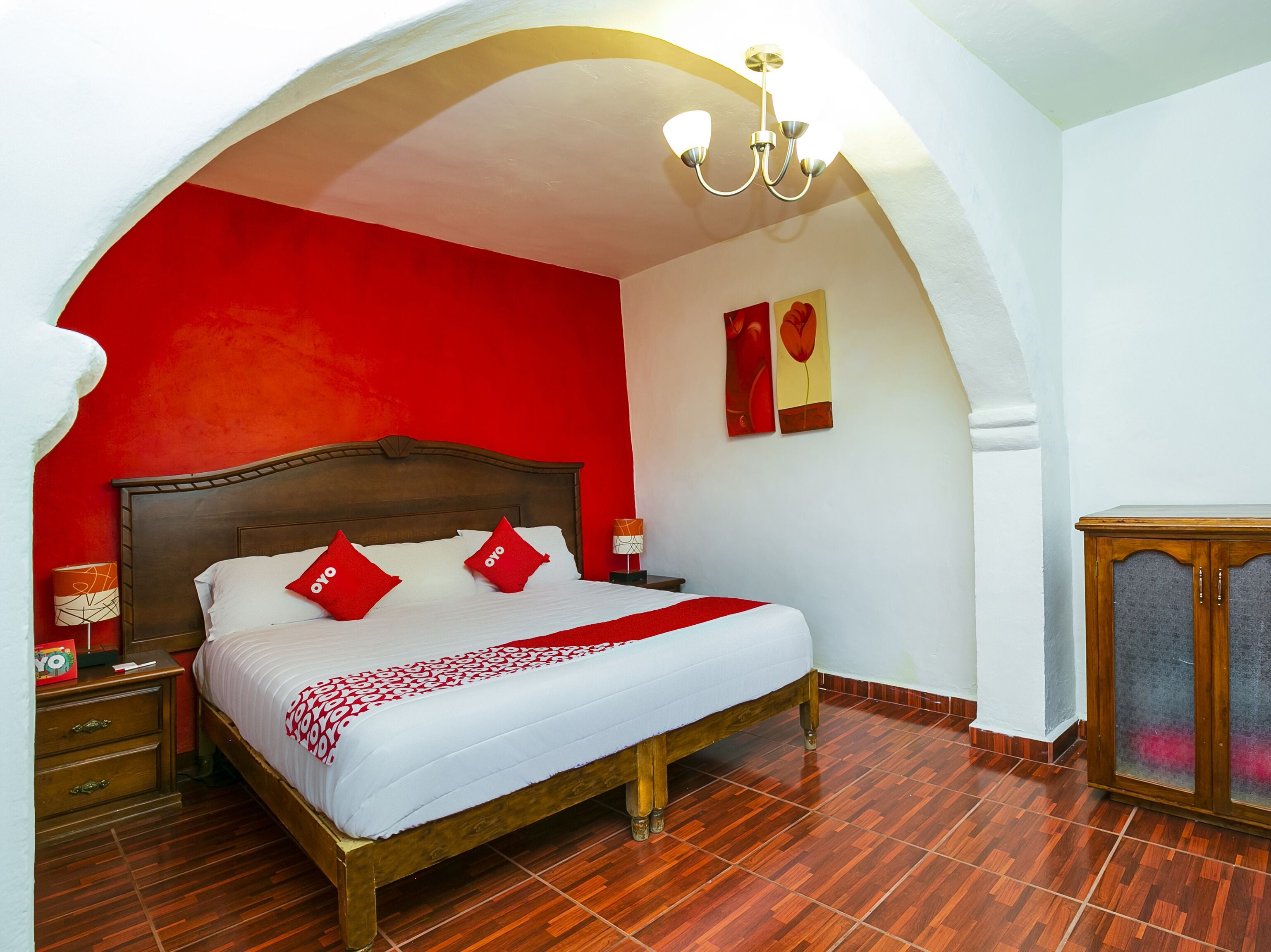 A room with a bed, a nightstand, a lamp, and a cabinet.