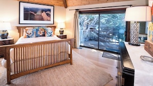 A bedroom with a wooden bed, a large window with a view of trees, and a mounted television. - September and October dates are available!!! Are Panoramic Ocean Views for you ? (Manchester)