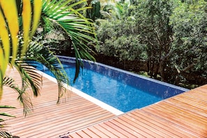 Ein rechteckiger Pool mit einer ihn umgebenden Holzterrasse.