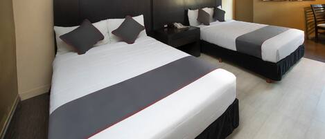 A hotel room with two beds, dark headboards, and a modern abstract painting on the wall.