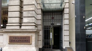 L’entrée du bâtiment Treasury, situé sur Collins Street, est marquée par une enseigne, une grille en métal et un sol carrelé.