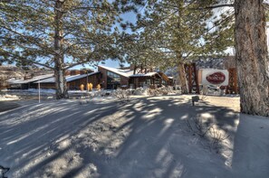 A modern lodge with a large wooden structure, a covered outdoor area, and a sign indicating 'The Prospector'.