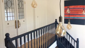 Eine Treppe mit schwarzen Spindeln und einer weißen Tür mit Glasfeldern.