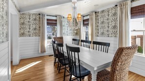 A dining room with a white table, black chairs, and a chandelier. - Historic home in seaside village of Swansboro w/ private beach parking  (Swansboro)