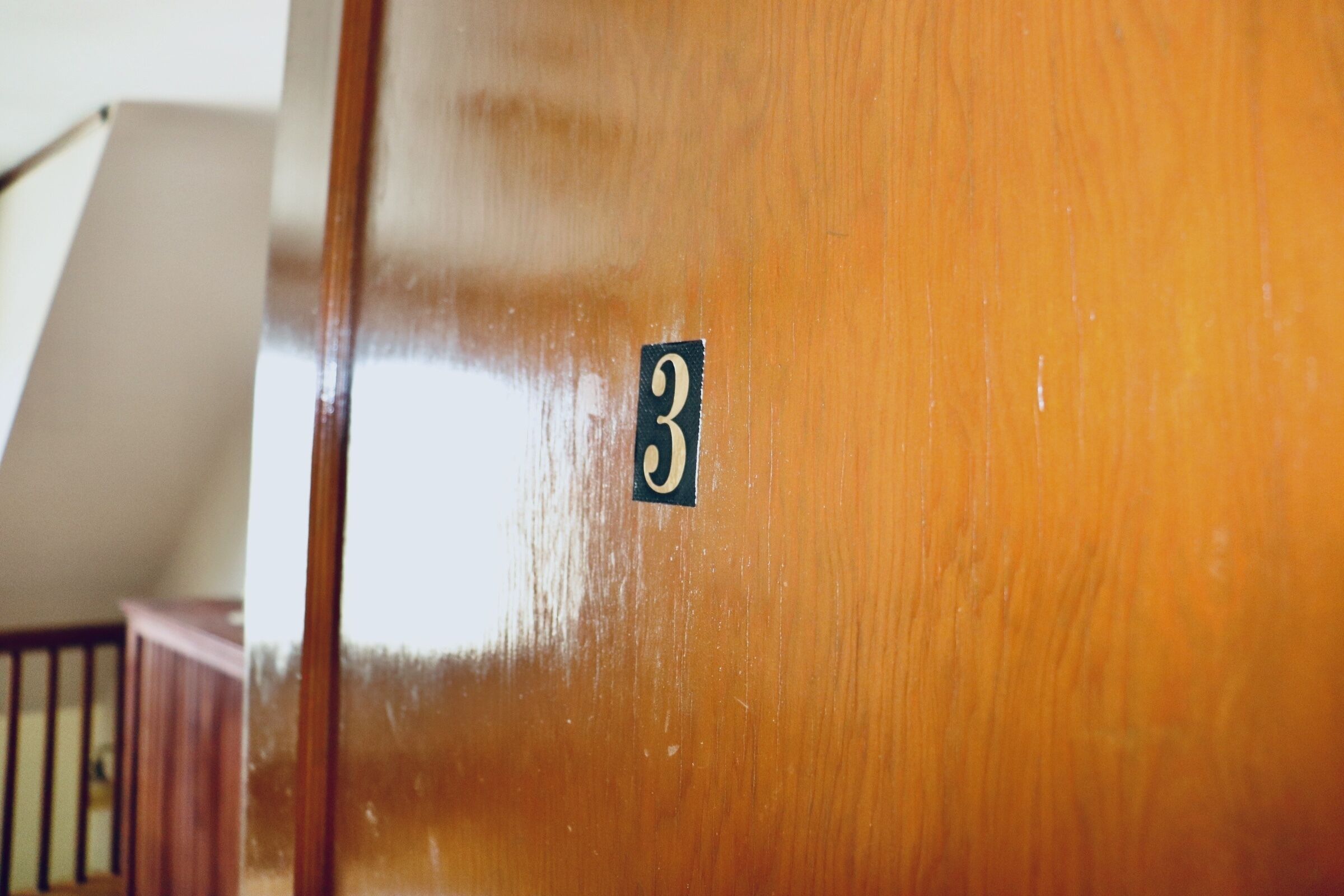 A wooden door with a number '3' sticker.