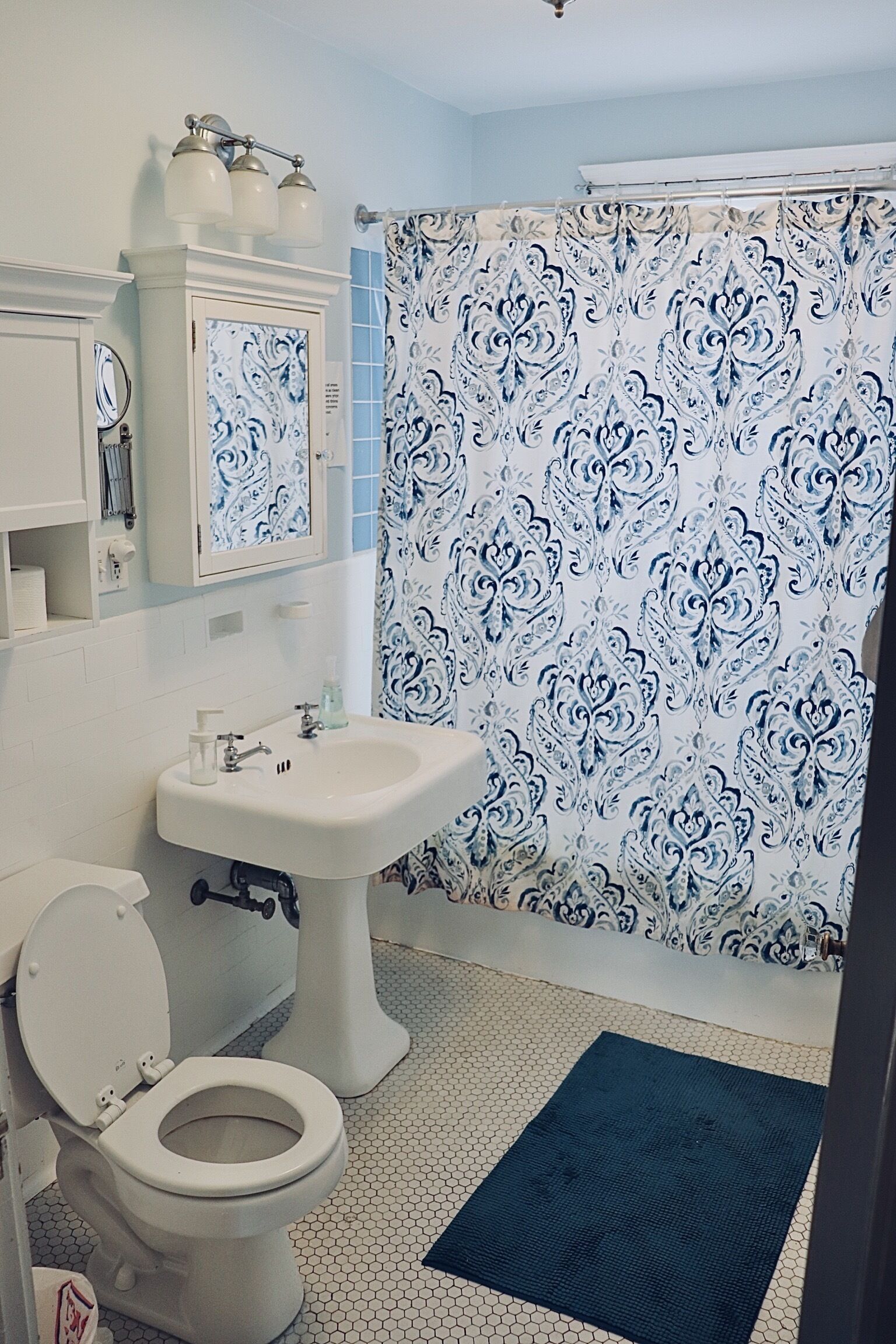 A bathroom with a toilet, sink, and shower curtain.