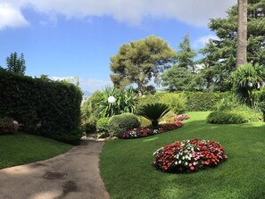 A well-maintained garden with a variety of plants and flowers, a clear pathway, and a view of the sky. - Studio A/C 'La Californie'-Upscale Quiet Residence (Cannes)
