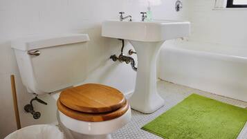 Une salle de bain avec des toilettes, un lavabo et une baignoire.