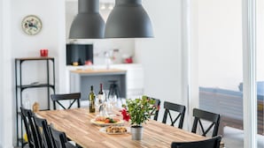 A dining table with chairs, a potted plant, and a variety of dishes. - Pet friendly home in Vrh (Vrh)