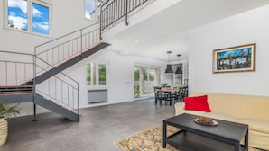 A spacious living area with a staircase, a dining area, and a sofa with a red pillow. - Pet friendly home in Vrh (Vrh)
