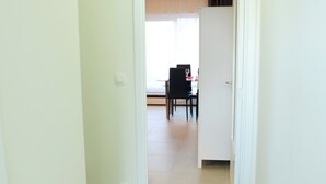 A hallway with a dining area at the end. - Fresh New EU COMMISSION area apartment  (Bruxelles)