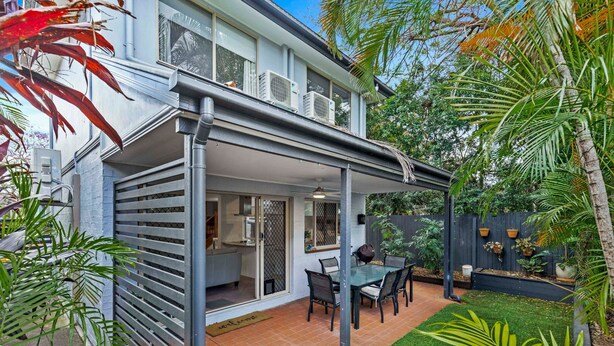A modern house with a covered patio, a dining area, and a well-maintained garden with various plants. - Bulimba Central 2BR -Sleeps 6, Courtyard (Balmoral)