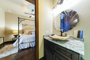 Relax in a stylish bedroom with a four-poster bed, bedside table, and large mirror.