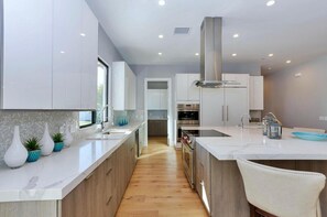 Enjoy cooking in this well-equipped kitchen with a central island, sink, and ample counter space.