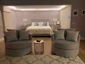Relax in a balanced and inviting space with a central bed, two nightstands, and a sofa set.