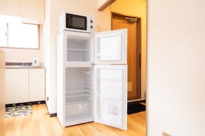 Kitchen features a microwave and refrigerator with ample storage.