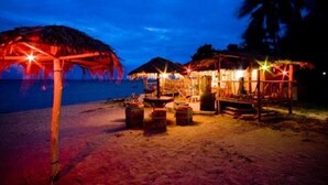 A beachside resort with thatched-roof huts and a sandy beach. - Power Beach Resort (Ko Pha-ngan)