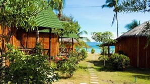 A pathway leading to a beachside property with wooden structures and lush greenery. - Power Beach Resort (Ko Pha-ngan)