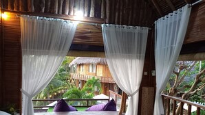 A room with a wooden ceiling and two beds with white and green bedding. - Room on the Real Tree (Bali)