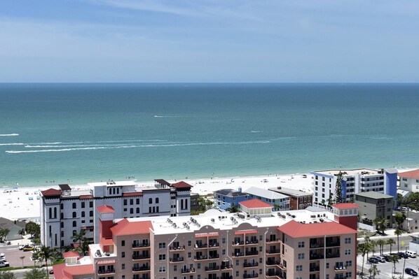 Ein Hotel an der Küste mit mehreren Etagen, Balkonen und Blick auf den Strand.