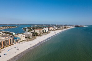 An aerial view of a coastal city with a long sandy beach, several multi-story buildings, and a marina. - A Private, Spacious and Updated Home Away From Home. Heated Pool. Paddleboards & Beach Gear! (Madeira Beach)