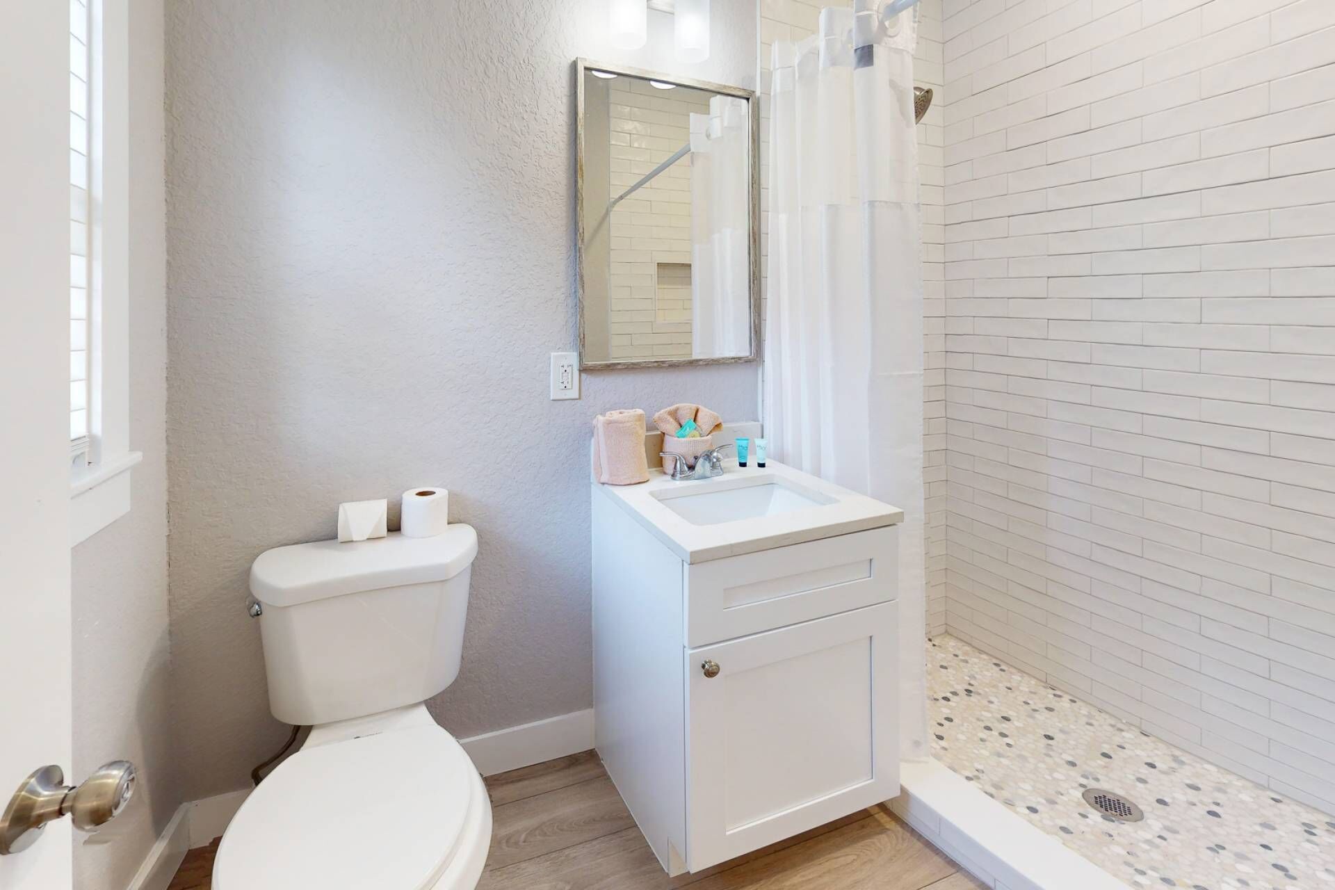 A bathroom with a toilet, sink, and shower.