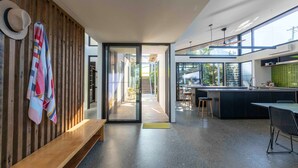 A modern kitchen with a large island, a dining area, and a view of the outdoors.