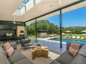 A modern outdoor living area with a pool, seating, and a barbecue setup. - Luxury Villas Narringa Ridgeview:Pool, Spa, Tennis (Skinners Shoot)