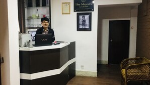 A reception desk with a laptop, a framed certificate, and a sign for "The Majestic Bed & Breakfast".