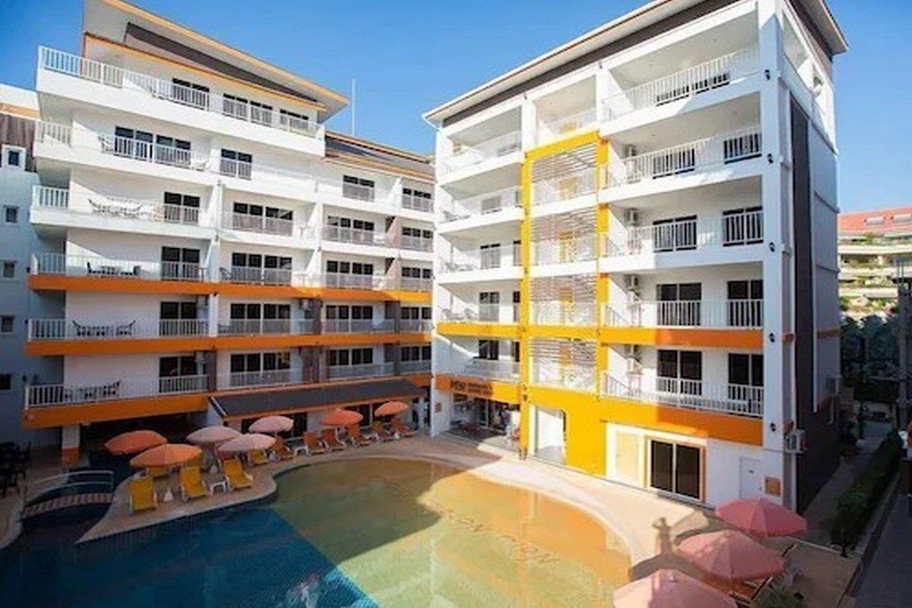 Un hôtel à plusieurs étages doté de balcons, d’une piscine et d’espaces de détente en plein air.