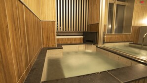 A wooden interior with a glass-enclosed area, possibly a spa or relaxation room, and a staircase leading to an upper level.