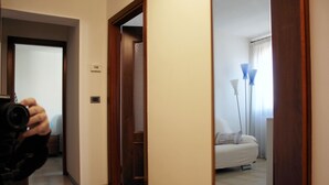 A hotel room with a bed, a nightstand, and a lamp. - Moira's House (Venezia)